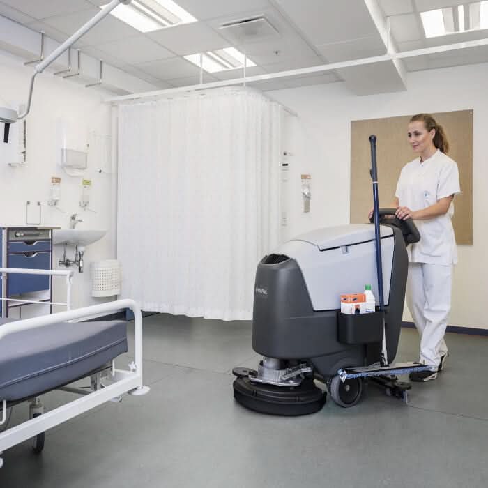 Grau-schwarze nilfisk scheuersaugmaschine ba551 cd mit langem griff und ladegerät für klinik- und gewerbereinigung