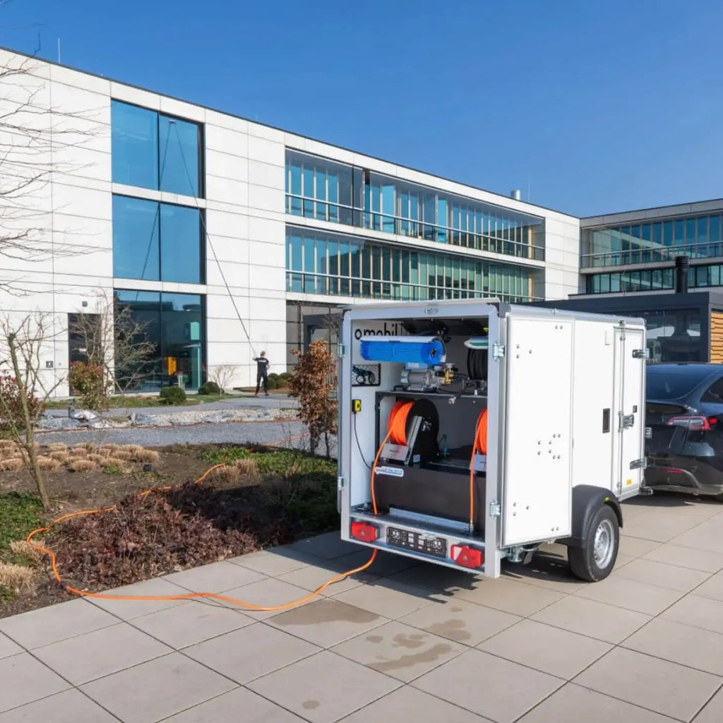 Weißer osmobil trailer v2 anhängersystem ohne osmobil pro x mit blauem und orangefarbenem reinigungsequipment sichtbar von hinten