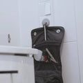 Schwarzer sauba steckdosenverschluss dodo stoff-organizer mit silbernen metallhaken und tasche mit nagelschere und nagellack
