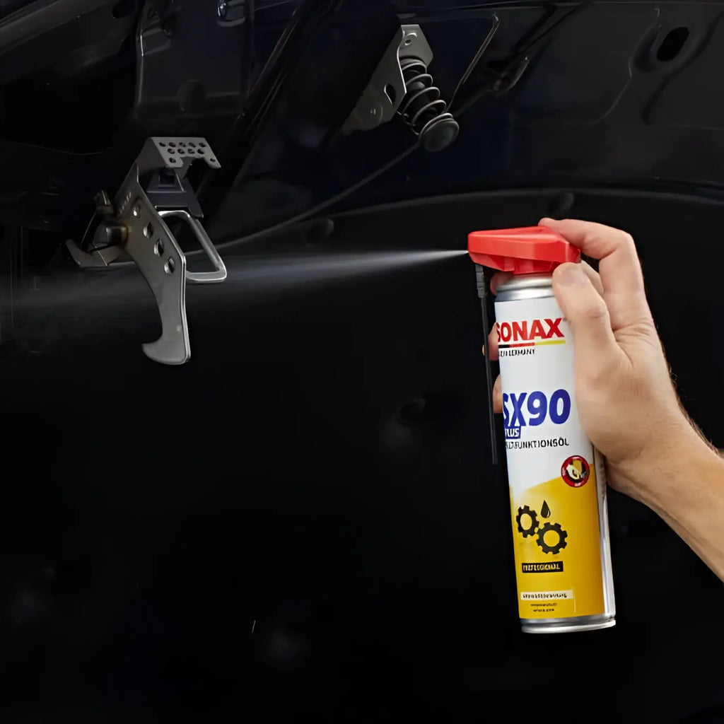 Eine hand hält eine sonax professional sx90 plus easyspray multifunktionsöldose mit rotem deckel und gelb silbernem design