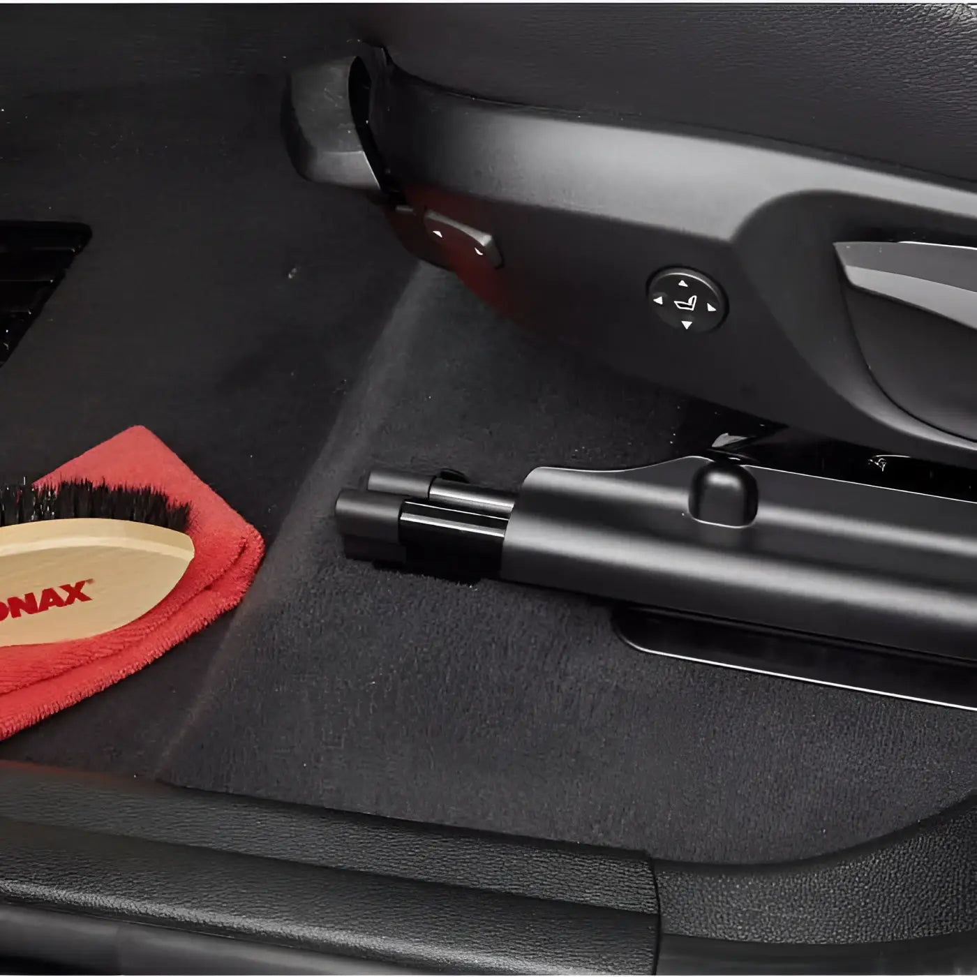 Schwarze plastikbürste mit rotem mikrofaser-Tuch und holzgriff sonax textil + lederbürste für auto innenraumpflege