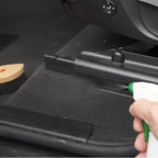 Schwarze kunststoff-autofußmatte mit strukturierter oberfläche und geformten kanten sonax textil lederbürste