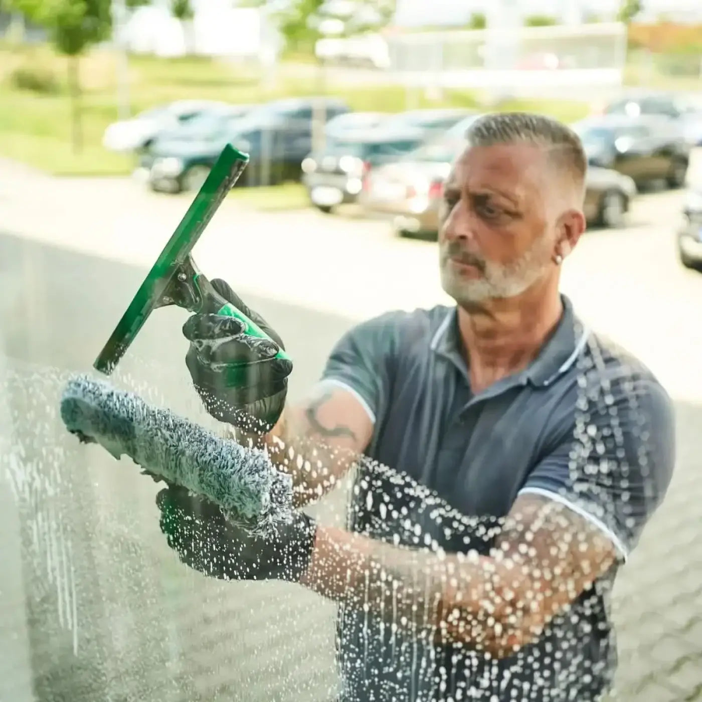 Grüner ungger ergotec fensterputzer mit schwarzem griff und strukturierter gummilippe im 6in1 set ak015